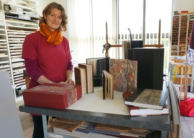 Anne Liégard, Maître Artisan relieur, dans son atelier des liens de la Mémoire à Baron-sur-Odon. (© Mireille Thiesse)