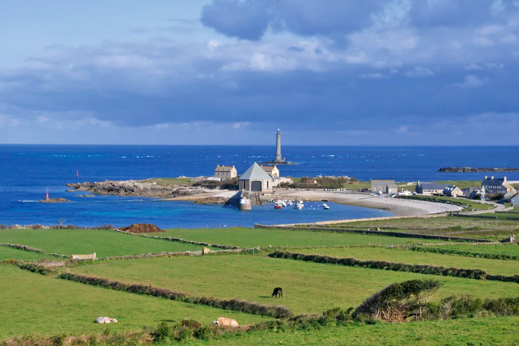 Le petit port de Goury, son phare et l’abri du canot de la station SNSM. Au large, les écumes nous font deviner le passage du raz Blanchard. (Photo Rodolphe Corbin © Patrimoine Normand)