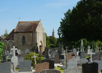 La chapelle Saint-Gervais de Briouze et l’if solitaire qui veille au milieu du cimetière. Au loin, la nouvelle église du bourg. (© Mireille Thiesse)