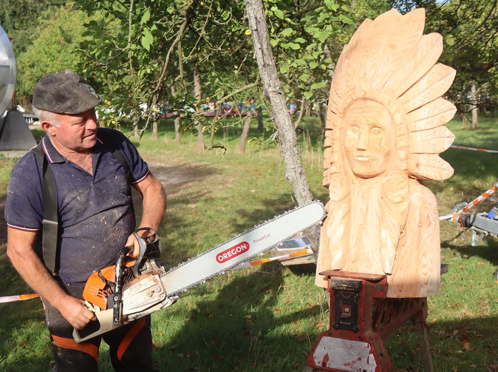 Le sculpteur Gérard Ferruel. La tronçonneuse caresse le bois pour restituer les moindres détails du sujet de la sculpture. (© Virginie Michelland)