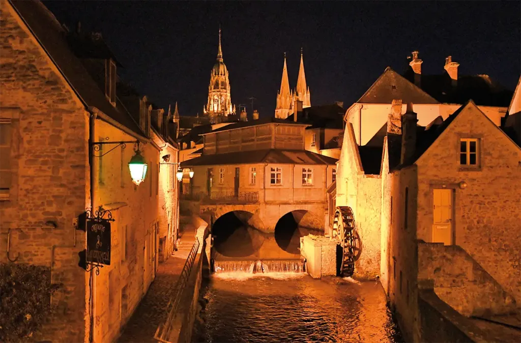 Bayeux. Promenade nocturne sur les bords de l'Aure. En arrière plan la cathédrale Notre-Dame de Bayeux, mélange de styles roman et gothique. (Photo Rodolphe Corbin © Patrimoine Normand)
