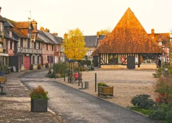 Place du centre de Beuvron-en-Auge avec maisons à colombages et halles à droite, village du Pays d’Auge en Normandie
