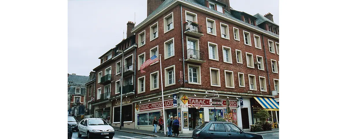 Au même emplacement, légèrement décalées vers l'est pour élargir l’entrée de la place Victor-Hugo, ces bâtisses sans âme ont remplacé ces merveilleuses constructions de bois. On aperçoit sur la gauche une des ailes de l’hôtel de ville. (© Érik Groult)