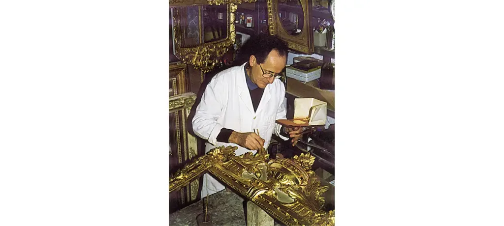 Le restaurateur Armel de la Bonnellière dans son atelier d'Audrieu. Humidification de la surface à dorer.