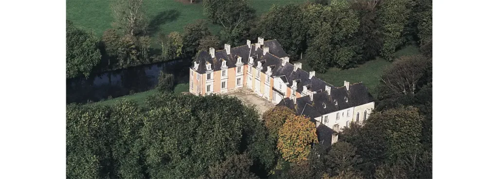 Vue aérienne du château de Franquetot à Coigny. Il est entouré d’un système de « canaux » que l’on aperçoit ici, et d’arbres pluricentenaires.