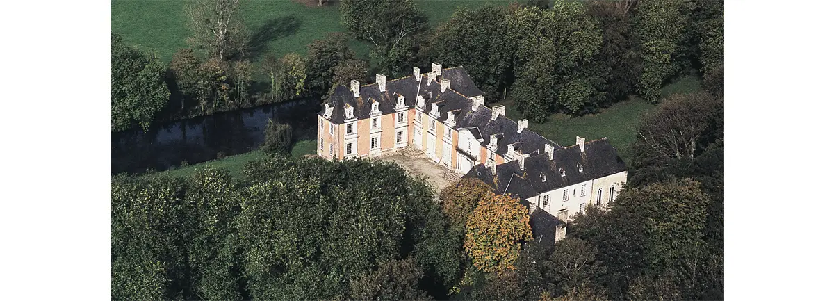 Vue aérienne du château de Franquetot à Coigny. Il est entouré d’un système de « canaux » que l’on aperçoit ici, et d’arbres pluricentenaires.
