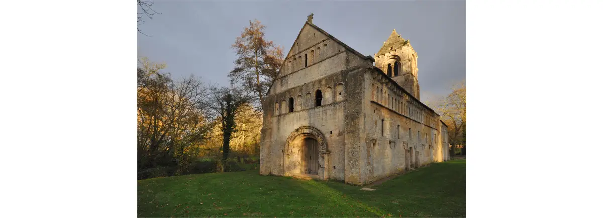 Photo de l’église de Thaon, côté sud-est. Remarquez sur la nef, les arcades bouchées et les chapiteaux bûchés.