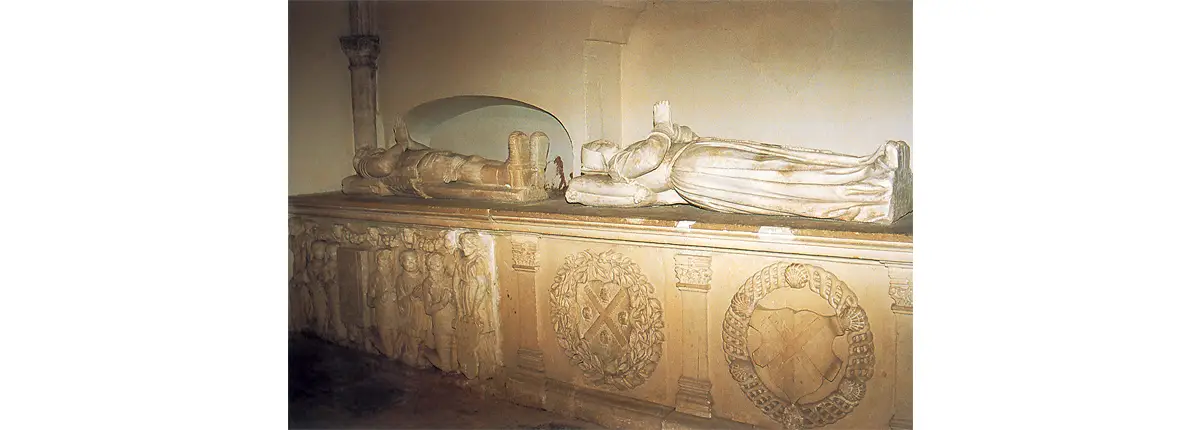 Photo du tombeau de Nicolas de Silly (à gauche) surmonté par son gisant et celui de Catherine de Sureau (amoiries entourées de feuilles de laurier) et d’Hervé IV de Longaunay, (armoiries entourées du collier de l’ordre de Saint-Michel) surmonté du tombeau de Marie Thésard.