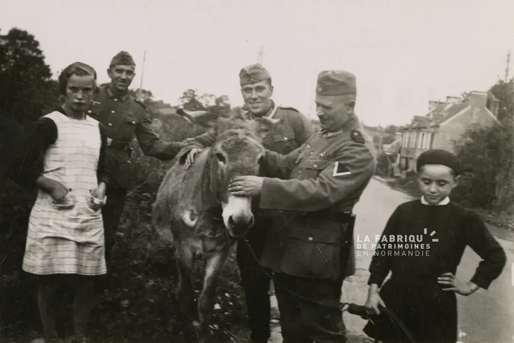 Deux enfants et leur âne, en compagnie de soldats allemands pendant l'Occupation.